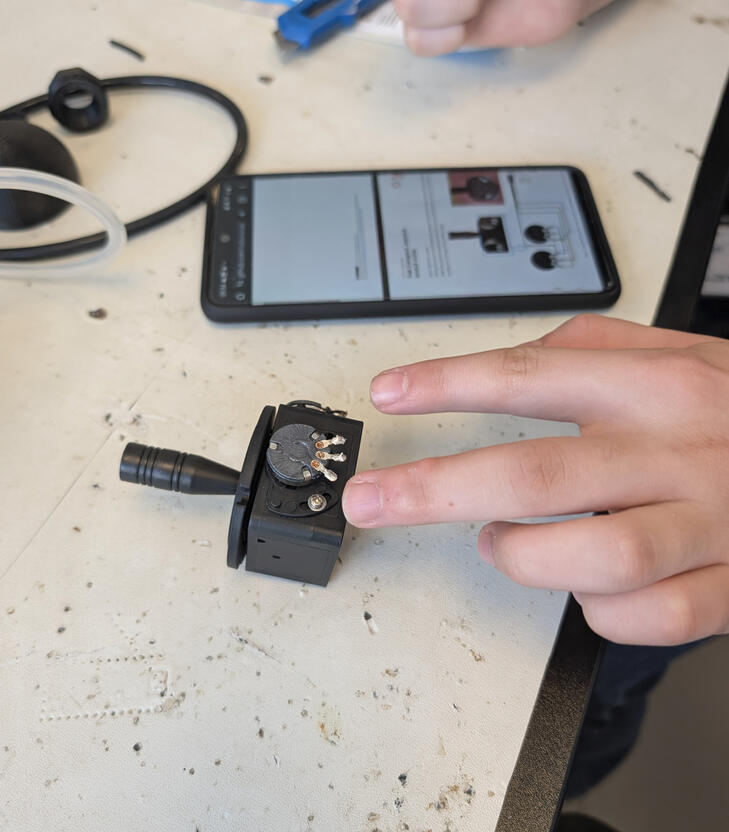 Engineer soldering wires to custom joystick.