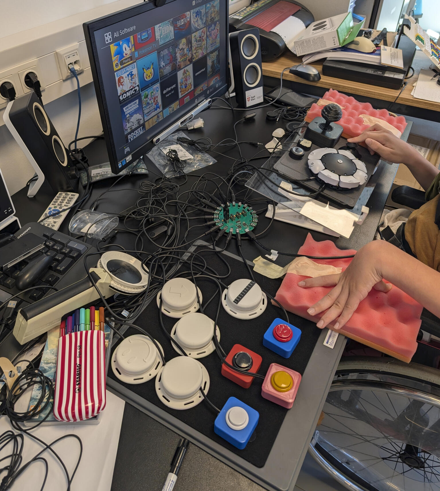 Play testing of customized controller. User with cerebral palsy play testing their Sony Access Controller fitted with custom attachments.